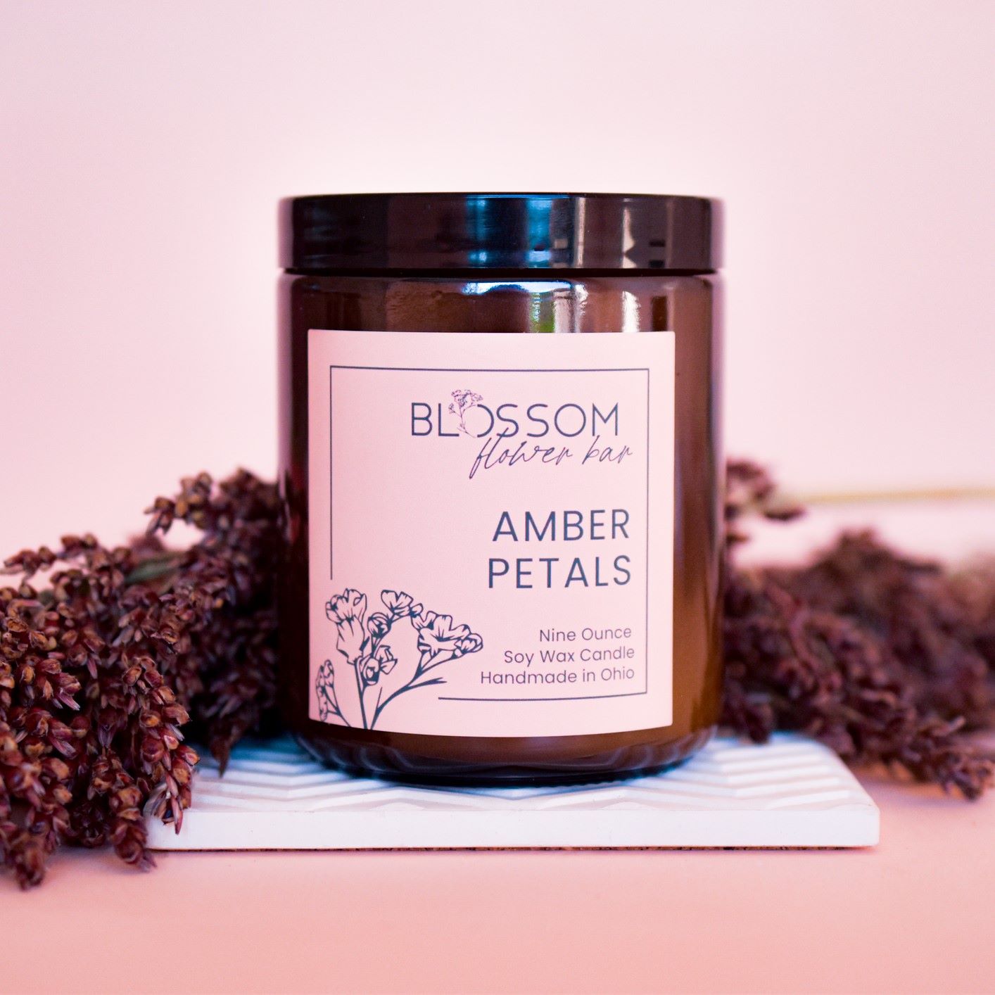 An amber jar candle with Blossom's label for Amber Petals