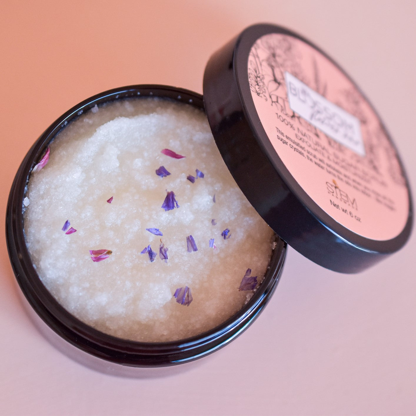 A jarred sugar scrub topped with flower flakes