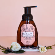 A bottle of Blossom's Foaming Hand Soap staged with flowers and lavender