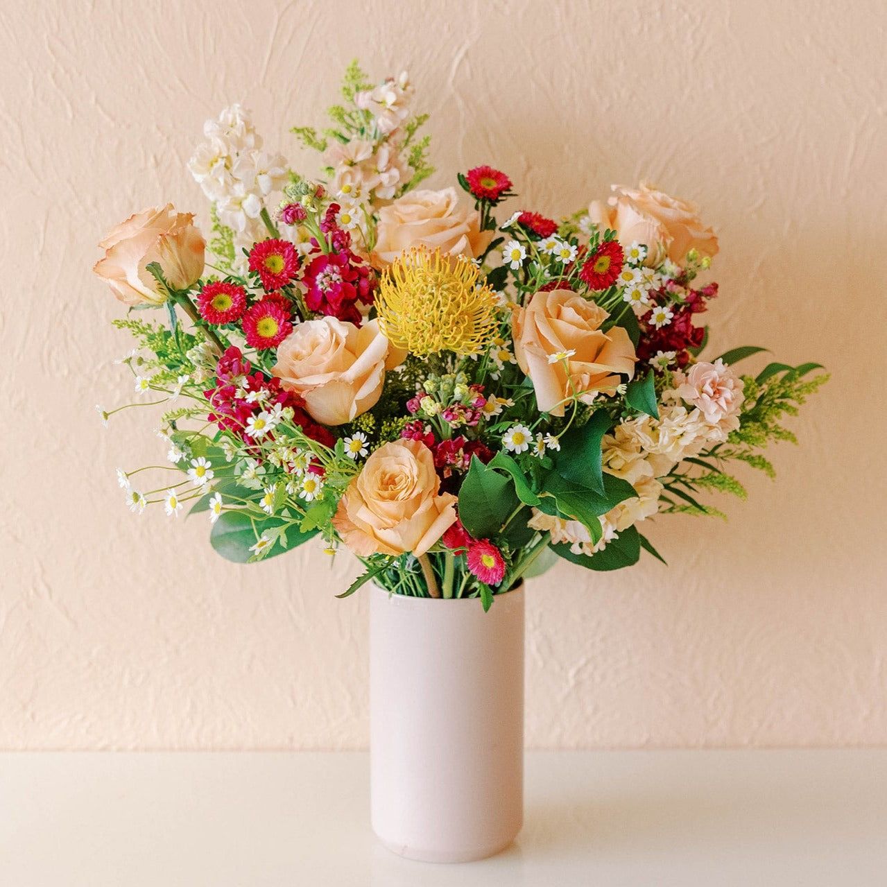 Tall statement arrangement with stock, china aster, roses, chamomile, pincushion protea