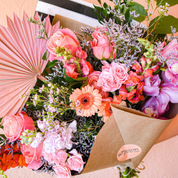 A detailed view of vibrant flowers arranged with peach, pink, purple and other colors