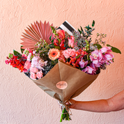 A wrap loaded with fresh flowers: spray roses, snapdragons, gerbera daisies, orchids, waxflower, roses and more