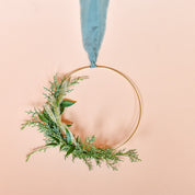 a bunch of greens bundled together on a gold frame wreath