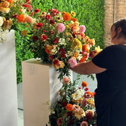 a Blossom team member setting a floral arrangement on a pillar for a special event